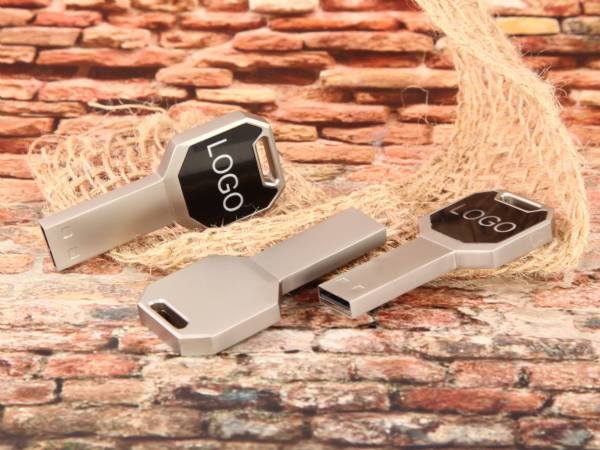 USB-Sticks in Schlüssel-Form mit individueller Bedruckung für Logos auf schwarzem Hintergrund. Ideal als Werbeartikel.