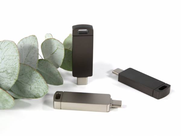 Drei moderne USB-Sticks in elegantem Design, umgeben von Eukalyptusblättern, ideal für individuelle Markenpräsentationen.