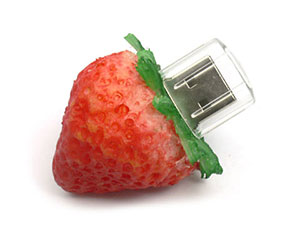 USB-Stick in Form einer Erdbeere, ideal für kreative Werbeaktionen mit Platz für ein individuelles Logo.