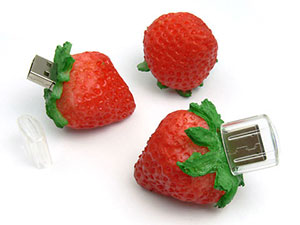 USB-Stick in Erdbeerform mit grünem Laub, ideal für kreative Werbung und individuelle Logo-Druckmöglichkeiten.
