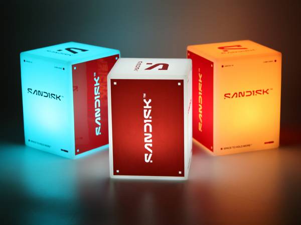 Leuchtende LED-Tischleuchten in cube-Form mit verschiedenen Farben und dem Logo von Sandisk. Ideal für Werbung und Events.