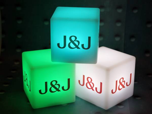 Leuchtende Würfel in verschiedenen Farben mit dem Logo „J&J“ für kreative Werbeaktionen und stimmungsvolle Beleuchtung.