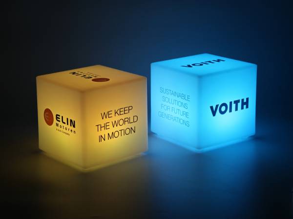 Leuchtwürfel mit den Logos von ELIN und Voith sowie den Slogans zu nachhaltigen Lösungen und Bewegung.
