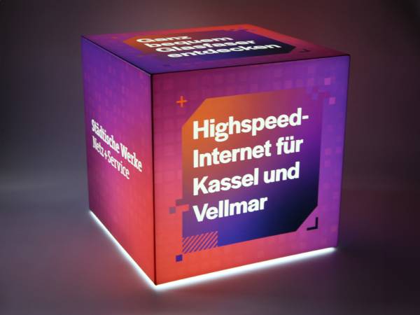 Leuchtender Sitzwürfel mit Werbebotschaft für Highspeed-Internet in Kassel und Vellmar. Modernes Design in lila und orange.