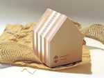 Holzfigur in Form eines Hauses mit durchscheinenden Lamellen und bedrucktem Logo 