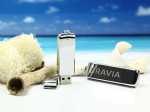 USB-Sticks in schimmerndem Design, platziert auf hellem Sand und maritime Dekorationen. Ideal für Promotions und Branding.