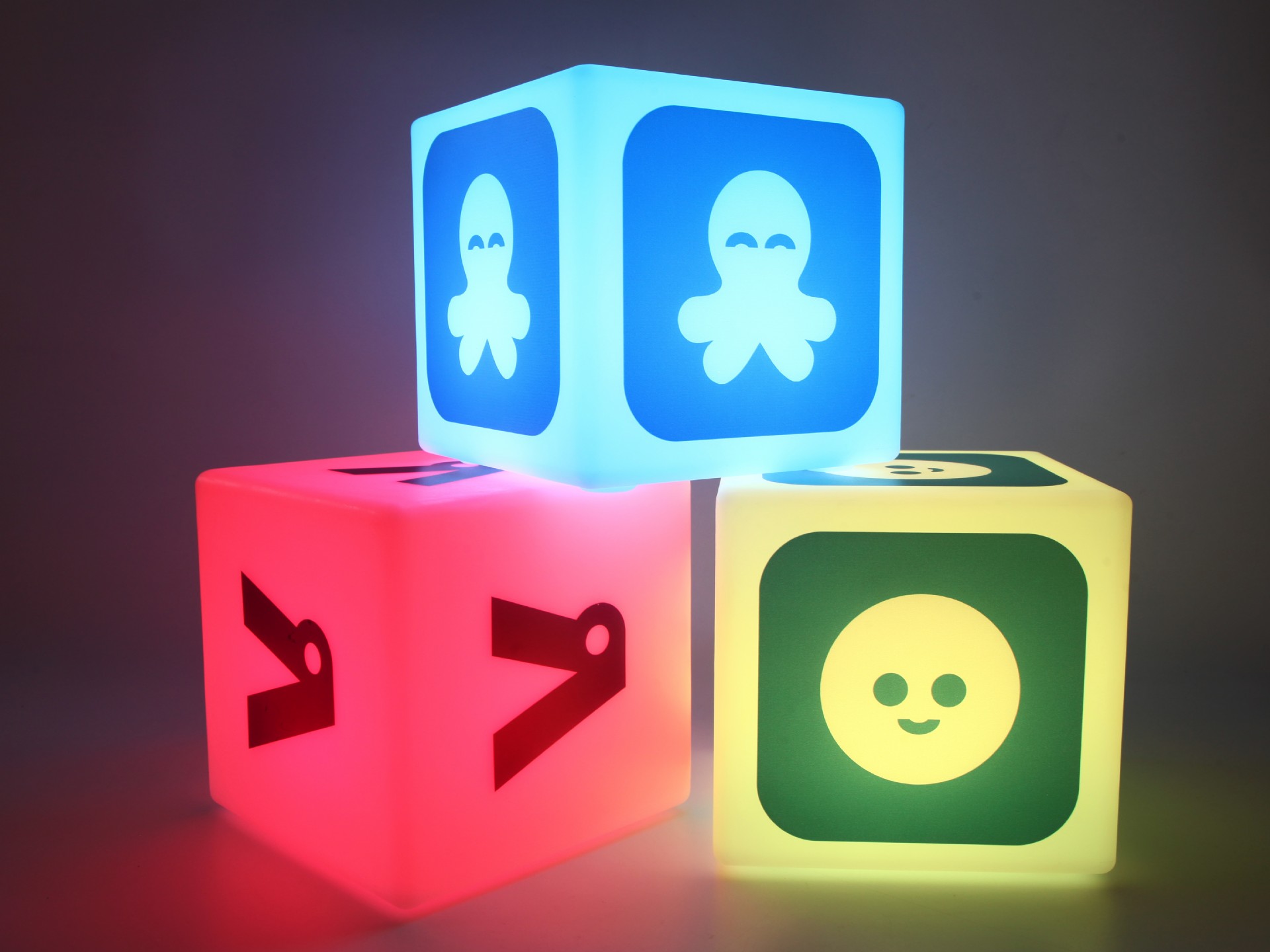 Leuchtende Würfel mit verschiedenen Symbolen, ideal für messetechnische Präsentationen und kreative Raumgestaltung.