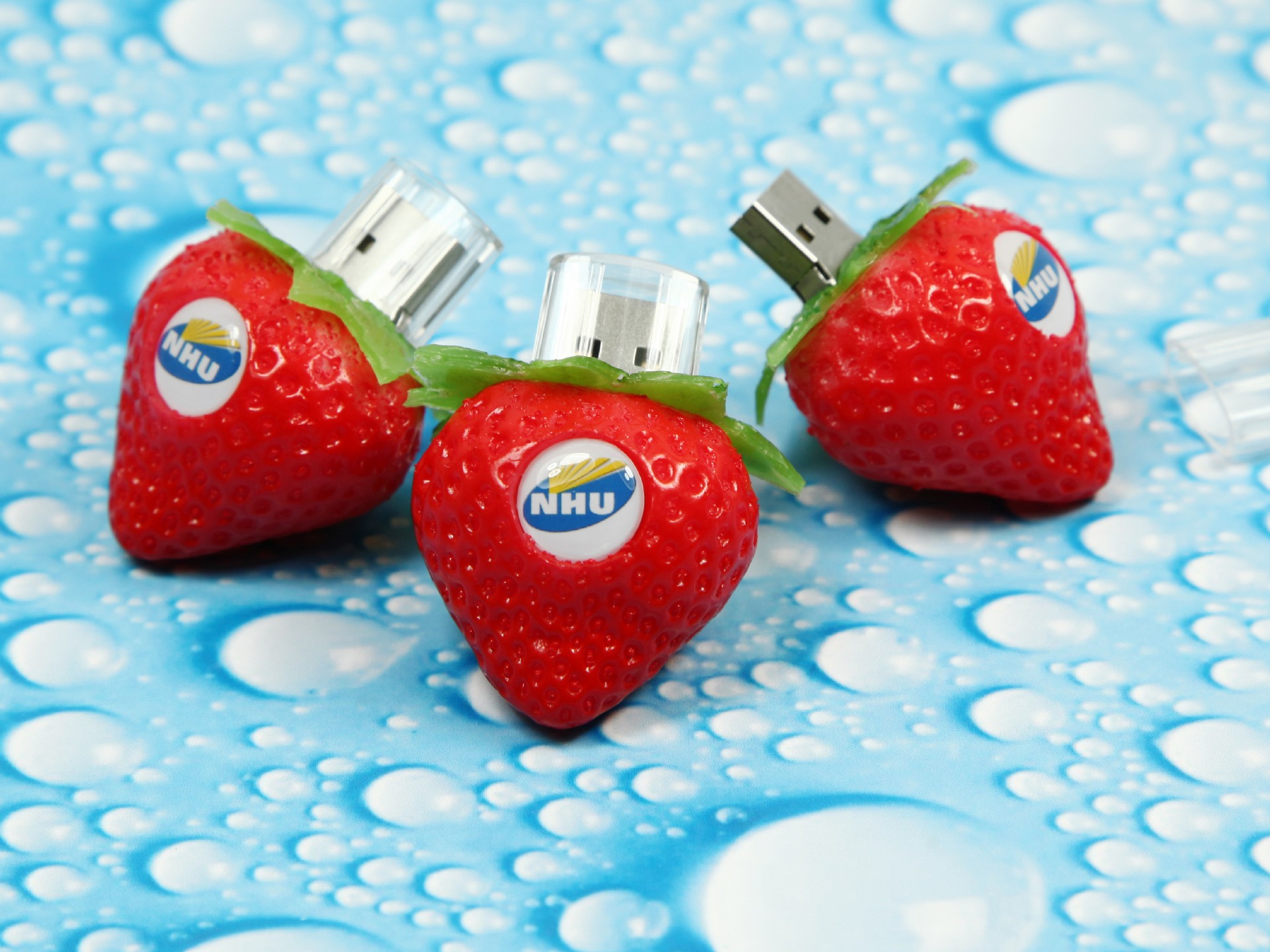 USB-Sticks in Erdbeerform mit individuellem Logo-Bereich und transparenten Kappen, perfekt für kreative Werbung.