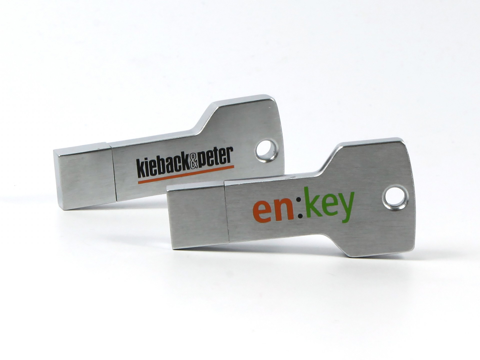 Zwei schlüsselförmige USB-Sticks aus Edelstahl mit individuell bedruckten Logos in orange und grün.