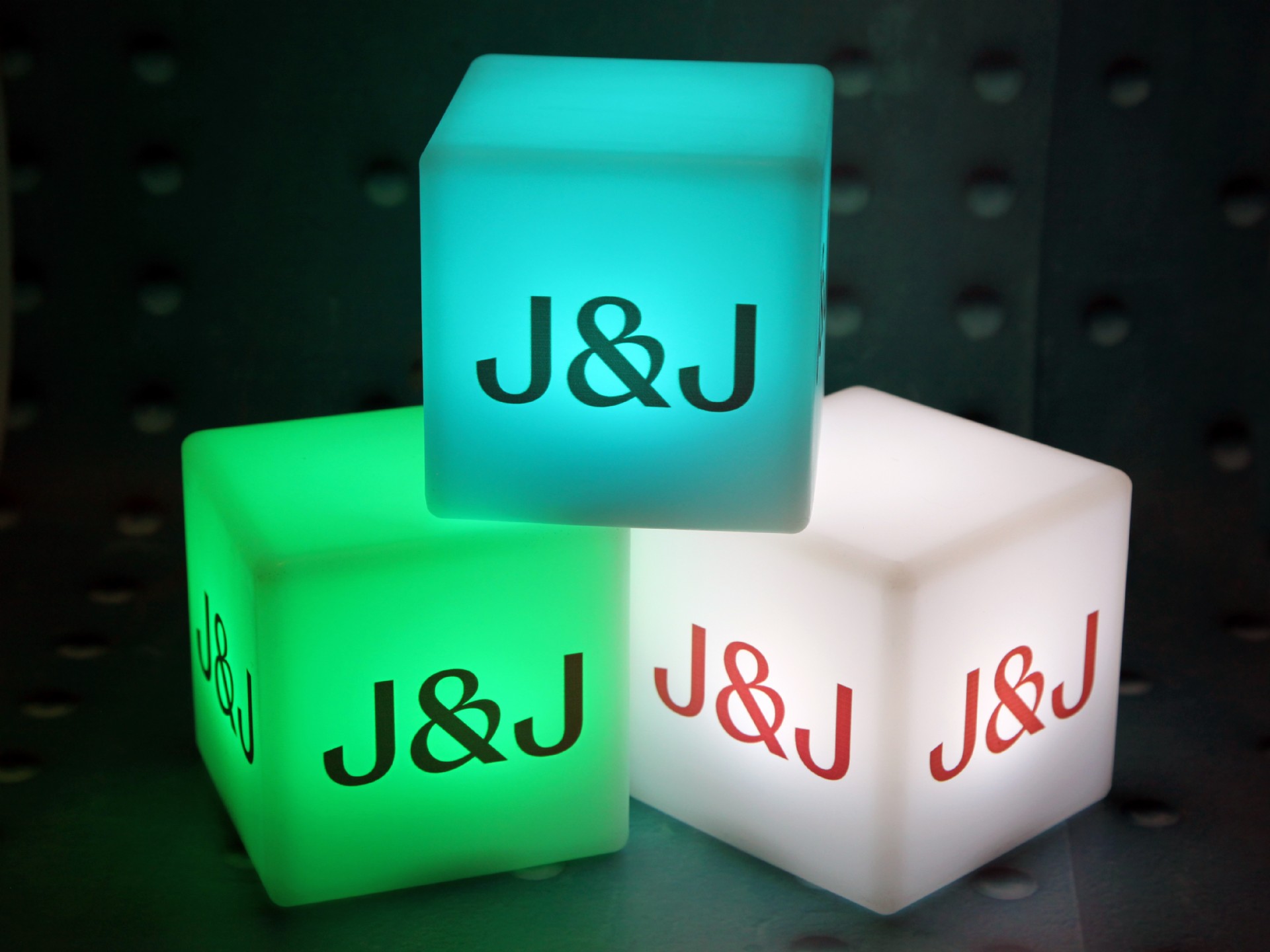 Leuchtende Würfel in verschiedenen Farben mit dem Logo „J&J“ für kreative Werbeaktionen und stimmungsvolle Beleuchtung.