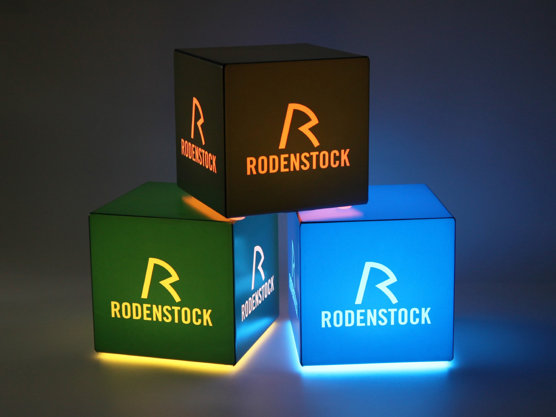 Leuchtende Würfel in verschiedenen Farben mit dem Logo von Rodenstock für auffällige Präsentationen und Werbung.