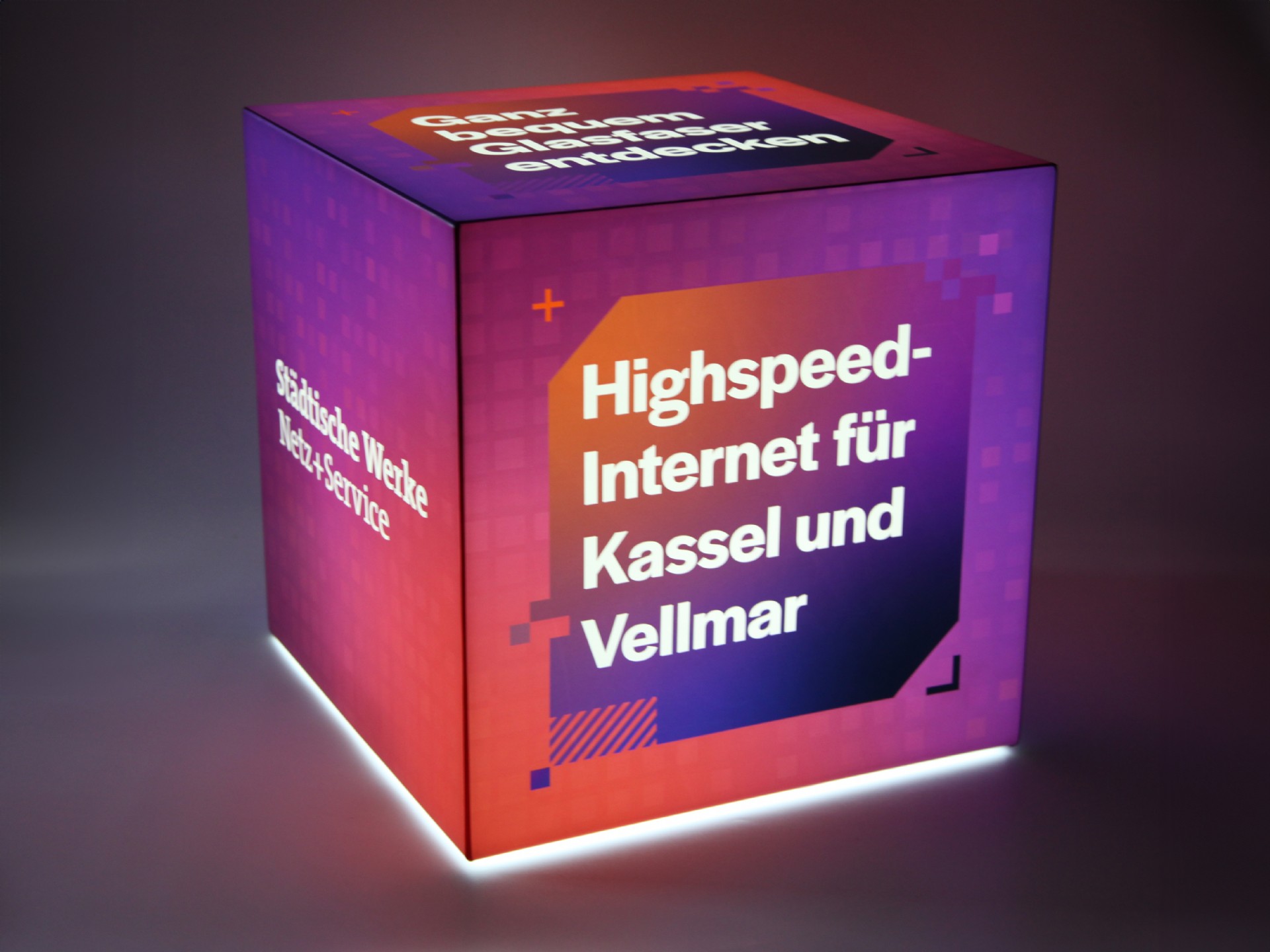 Leuchtender Sitzwürfel mit Werbebotschaft für Highspeed-Internet in Kassel und Vellmar. Modernes Design in lila und orange.
