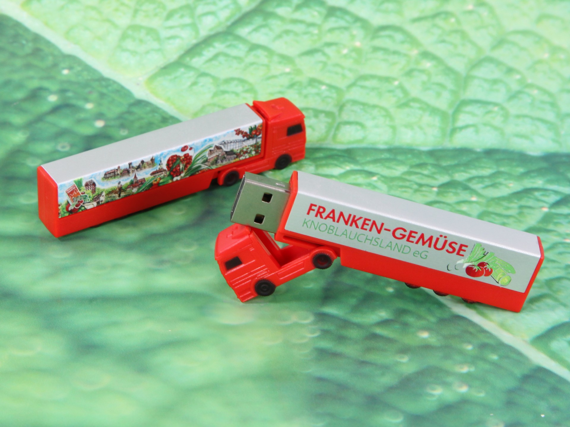 USB-Stick in Form eines roten Trucks mit personalisierbarem Logo-Bereich für kreative Werbezwecke.