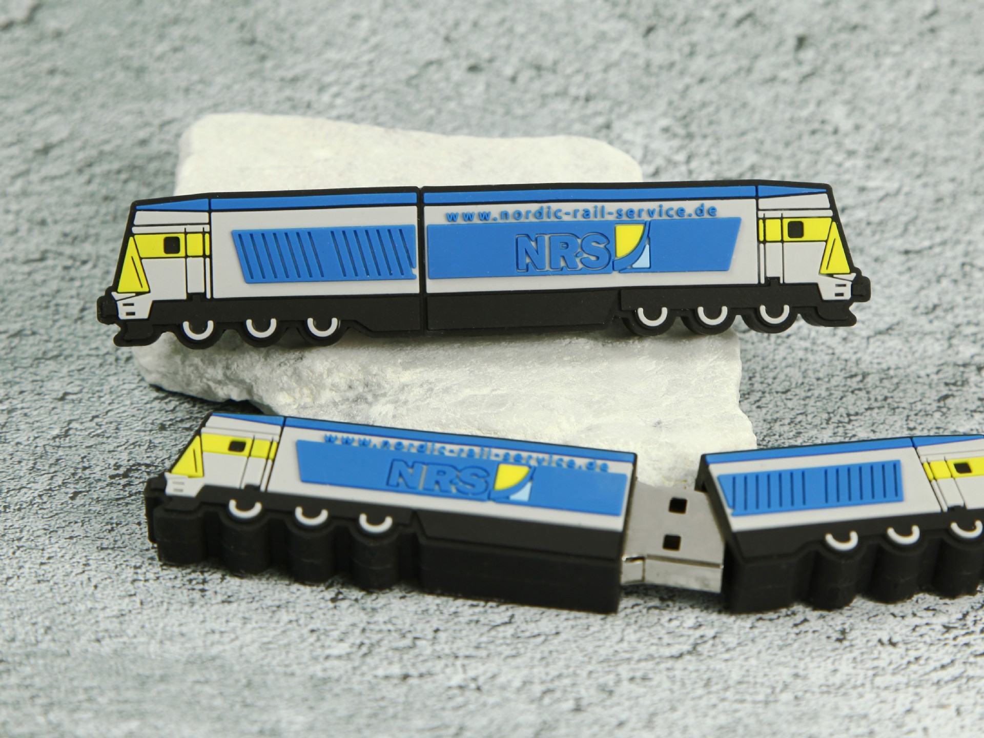 USB-Stick in Form einer Lokomotive mit individuellem Druck für Firmenlogos und Kontaktinformationen.